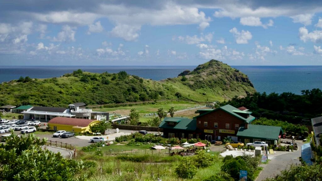 Grassy volcanic hills of Yongmeori Coast by the sea.