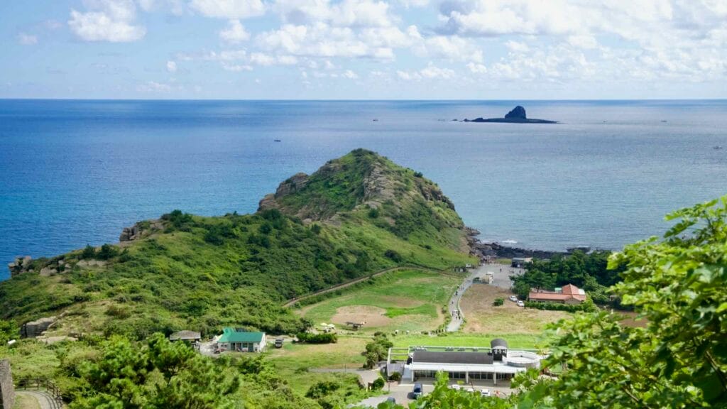 Panoramic view of Yongmeori Coast and sea from Sanbangsan, with an offshore islet beyond.