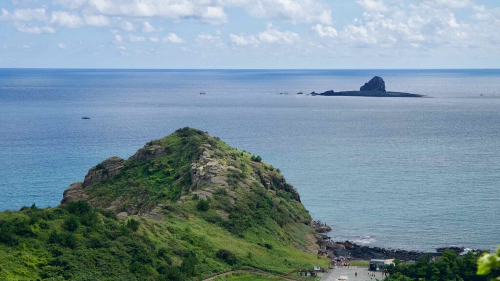 View of Yongmeori’s rocky promontory with Hyeongje Islet in water.