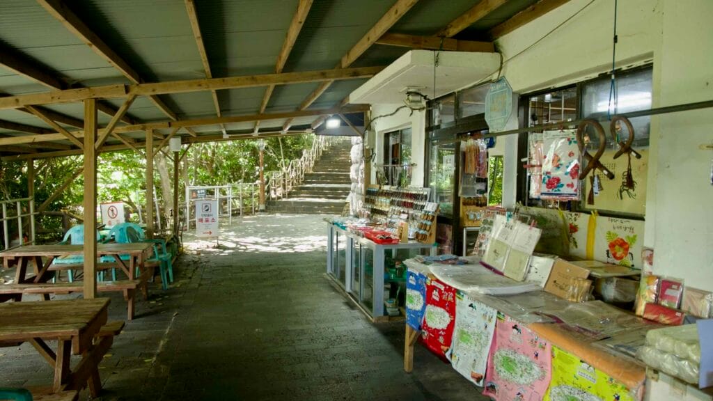 A covered walkway with souvenir stands and benches leads toward Bomunsa Temple on Sanbangsan.