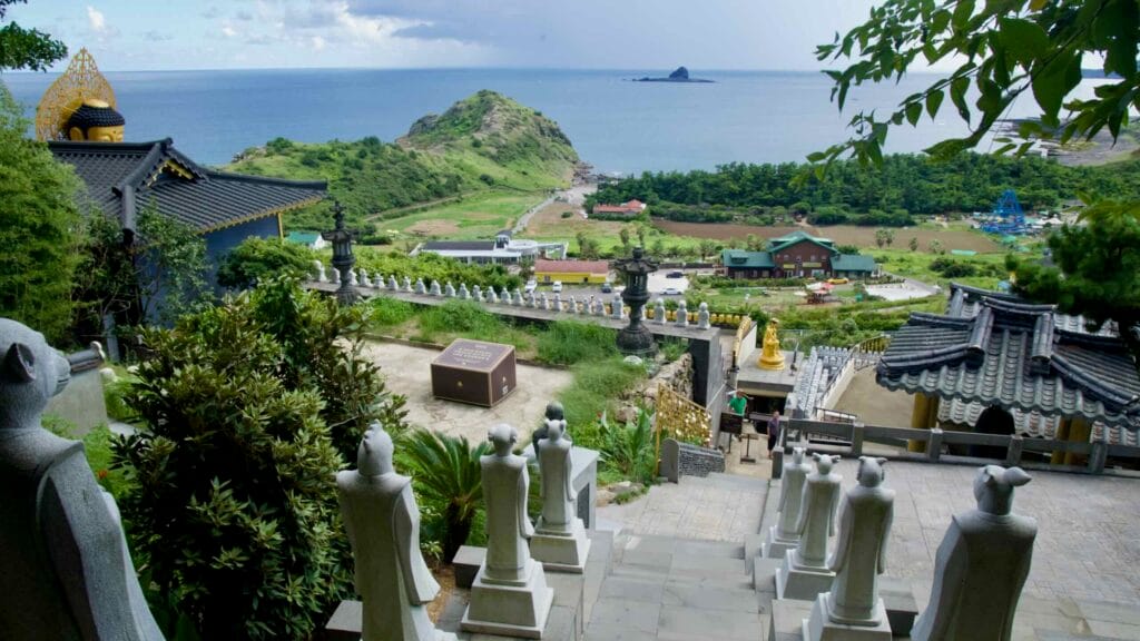 Path at Bomunsa Temple lined with zodiac statues descending toward the sea.