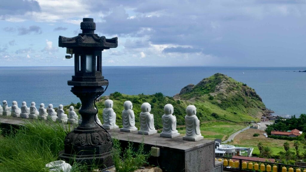 White Buddha statues at Bomunsa Temple overlooking the sea.