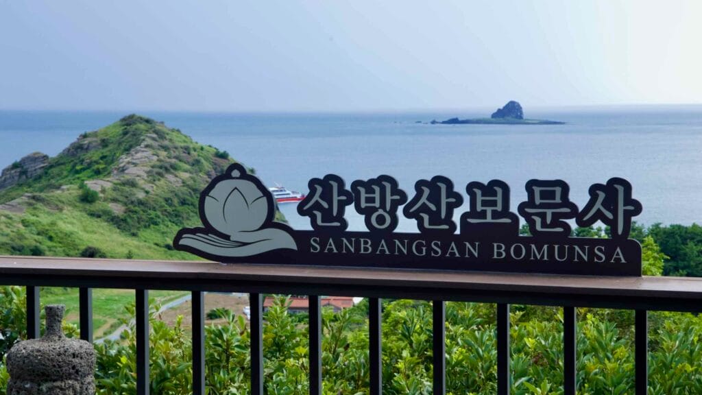 A viewpoint sign reading Sanbangsan Bomunsa overlooks the coastline and offshore island below.