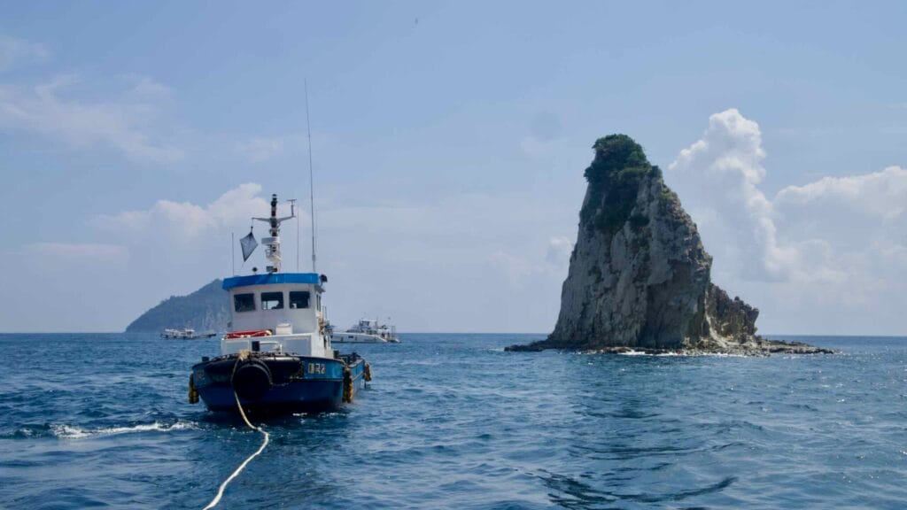 A workboat idles by Munseom’s sea stack off Seogwipo.