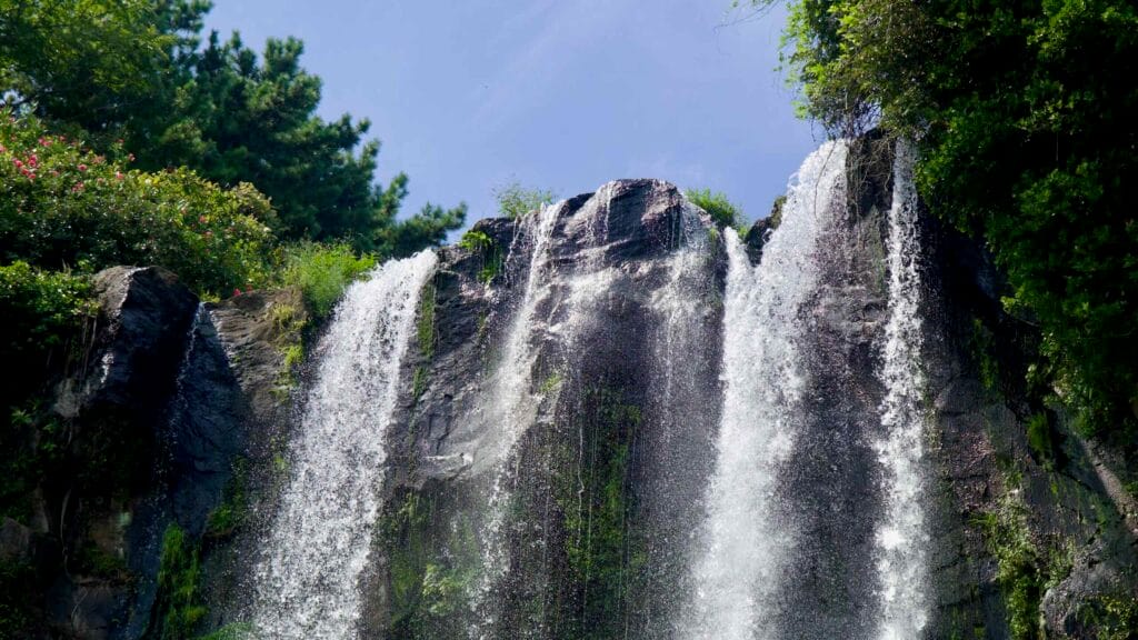 A close view of Jeongbang’s lip shows white veils of water spilling over dark rock.
