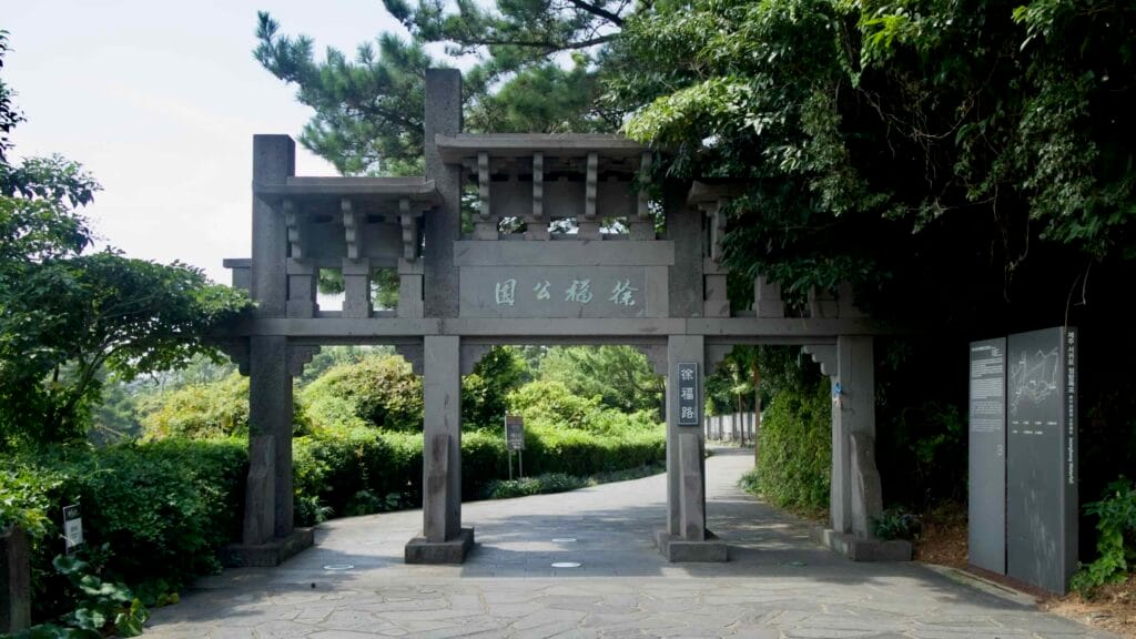 A traditional stone gate marks the entrance to the Jeongbang Falls park in Seogwipo.