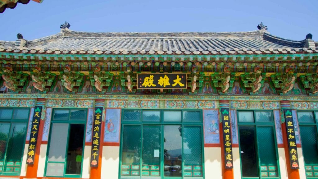 The Daeungjeon hall facade displays richly painted dancheong beams, calligraphy panels.