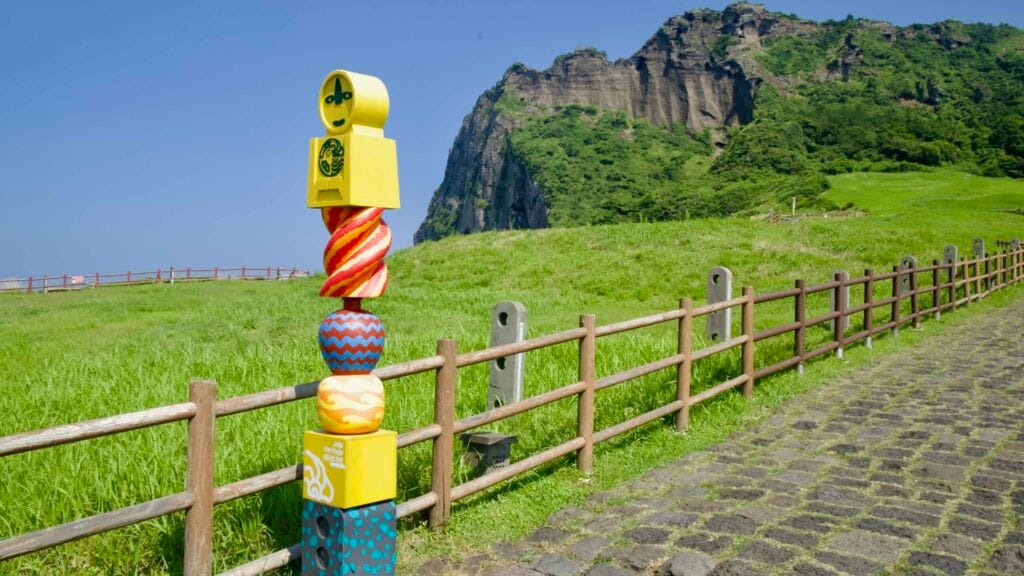A colorful totem marks the cobbled path that leads toward Seongsan Ilchulbong’s entrance.