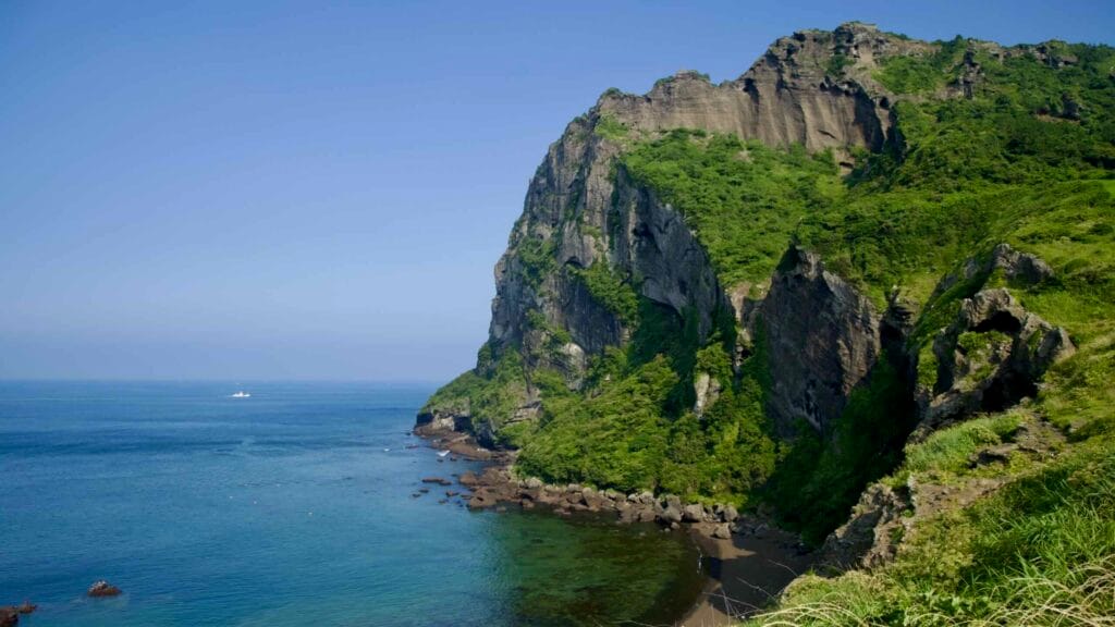 Weathered tuff walls tower above the shoreline along the Umutgae Coast at Seongsan Ilchulbong.