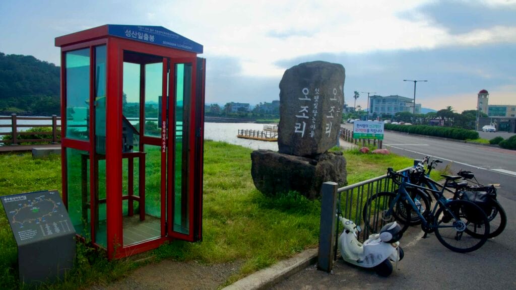 A red cycling certification booth stands beside the lagoon at Ojo-ri.