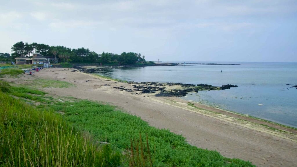 A sandy arc and dark lava outcrops frame the sheltered bay at Hado Beach.