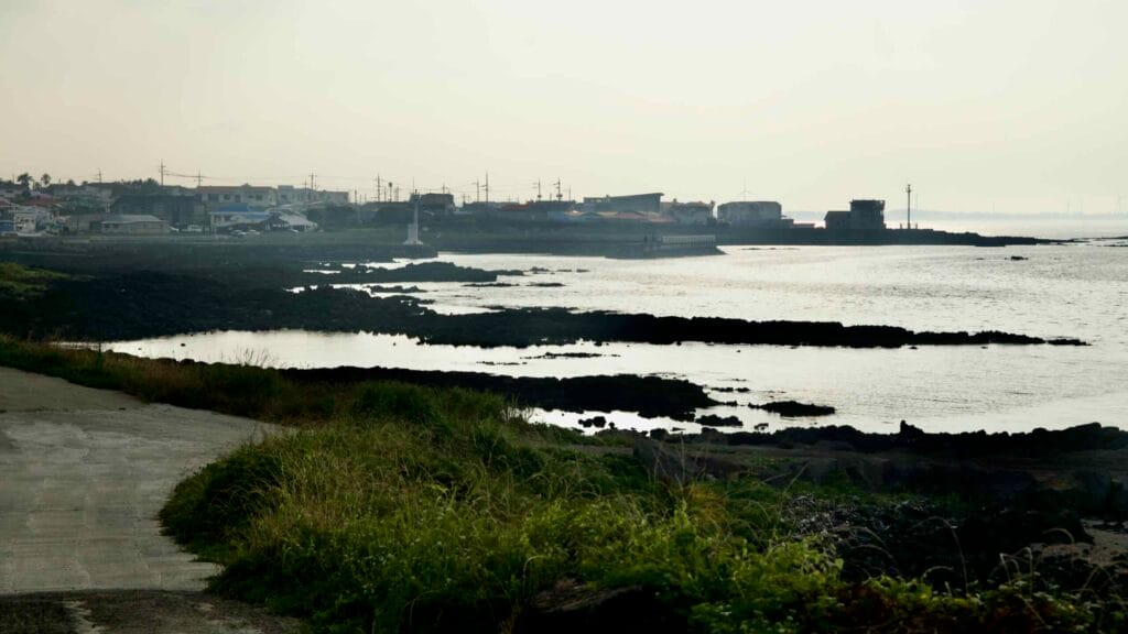 Evening light silhouettes Hado Village across the tidal lava flats.