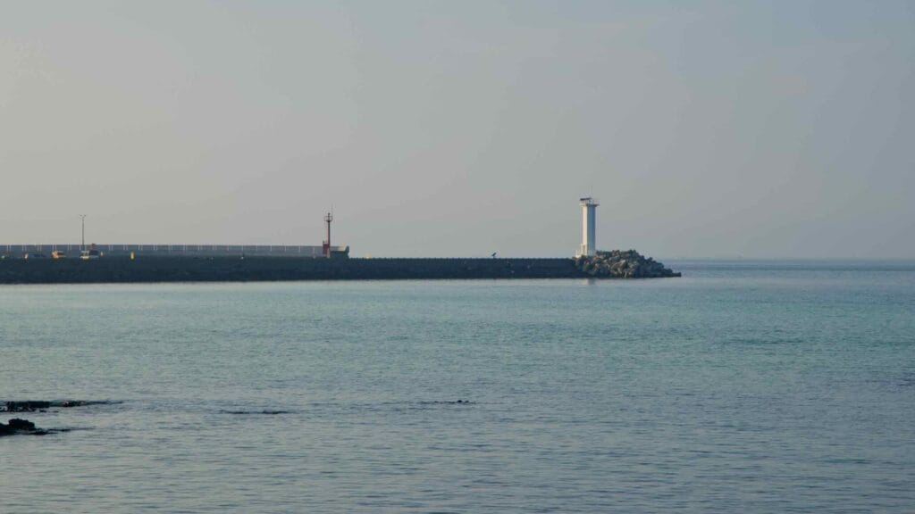 A white lighthouse stands proudly at the end of Sehwa Port’s long breakwater.