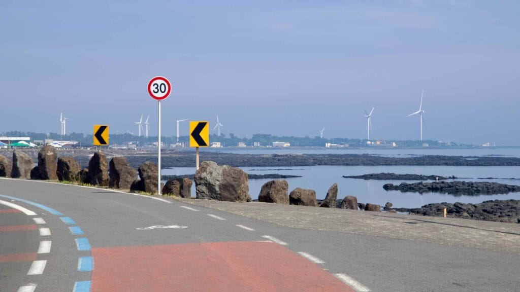 Wind turbines stand beyond tidal flats and lava reefs on the Handong-ri coast.