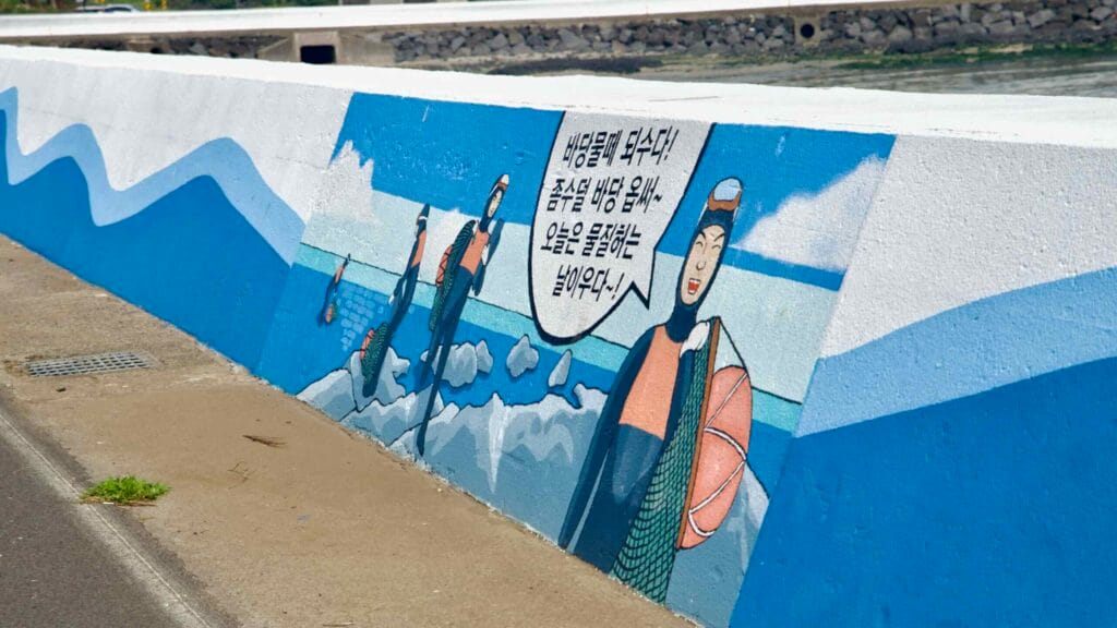A haenyeo divers mural decorates the Handong seawall along the coastal bike lane.