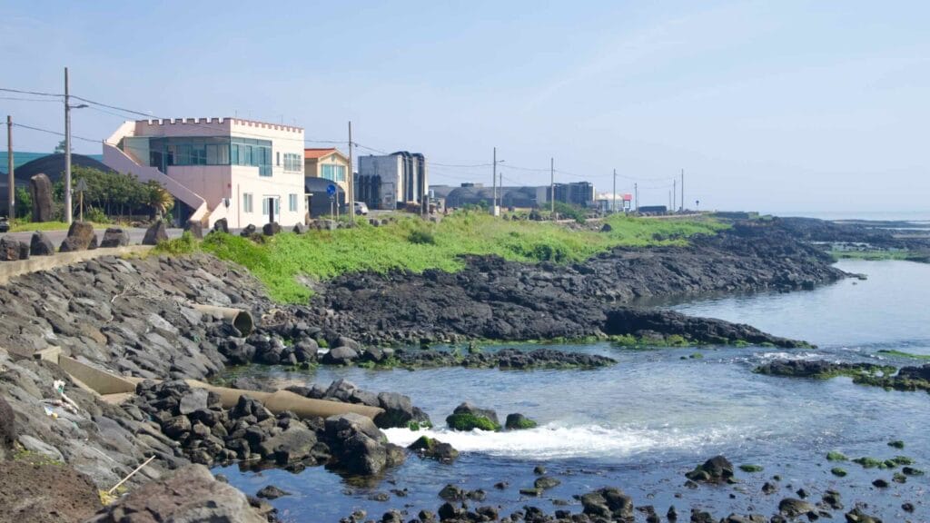 A rocky inlet below village houses and seawalls marks the Handong shoreline.