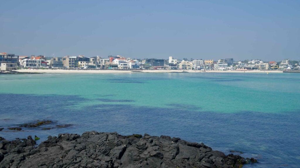 Basalt rocks frame Woljeongri Beach across a calm, emerald bay.
