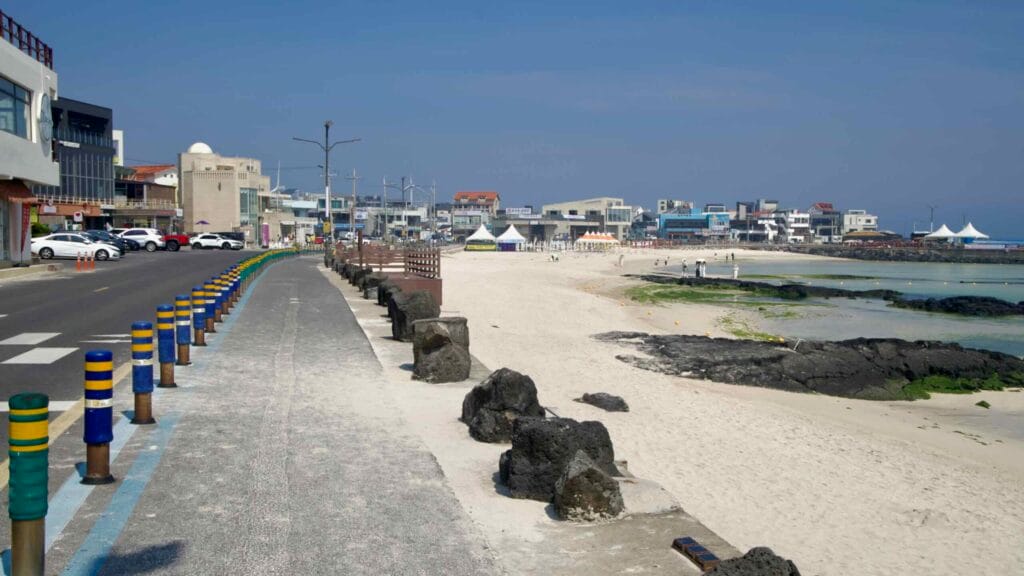 A beachfront road and bollards run beside Woljeongri’s white sand.