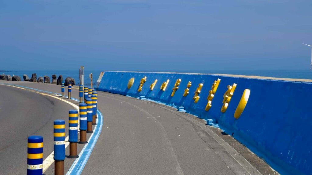 A blue seawall with yellow letters lines Woljeongri’s coastal road.