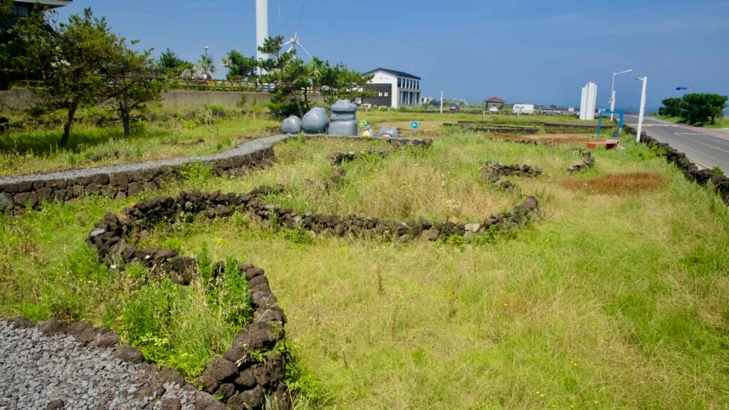 Curving Batdam dry‑stone walls wind across the park lawn.