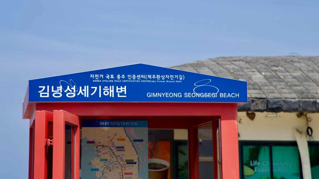 Blue sign crowns the Gimnyeong Seongsegi Beach certification booth for Jeju’s cycling route.