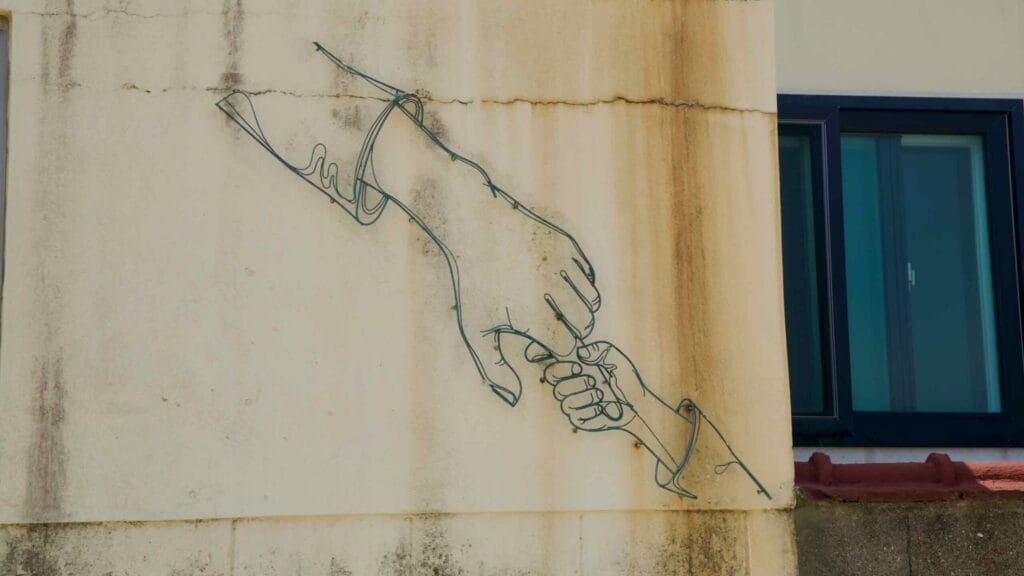 A wire sculpture of joined hands decorates a residential wall in Gimnyeong’s mural village.