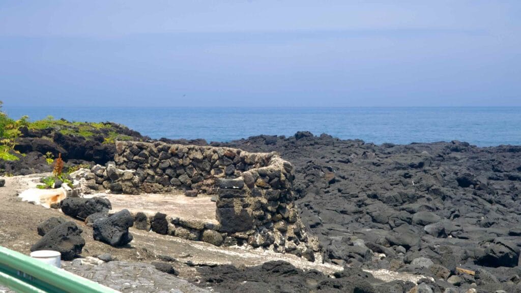 A lava-stone basin on the rocky shore at Dongbok Port in Gujwa-eup.