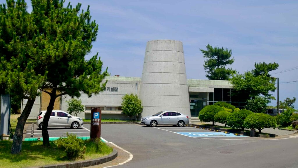 The cone-topped Neobeunsungi 4·3 Memorial Hall stands among pines and parking.