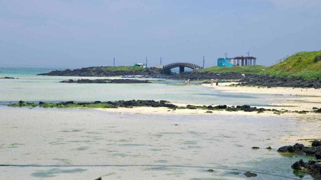 Shallow tidal flats stretch toward a small islet at Hamdeok Seoubong Beach.