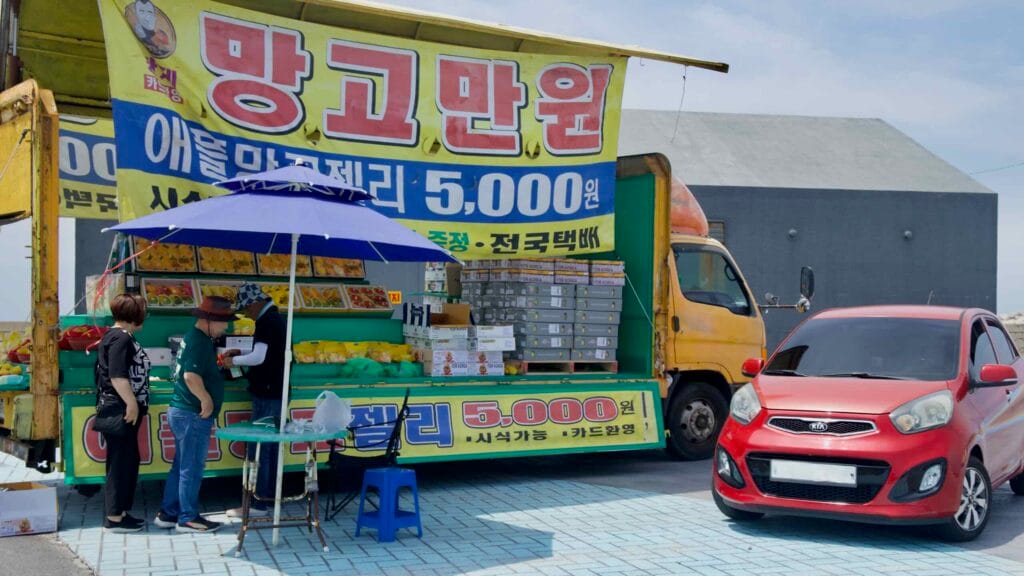 A fruit truck near Hamdeok sells mangoes and mango jelly.