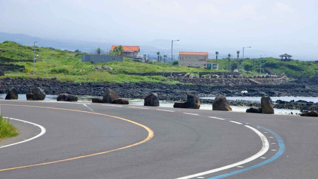 A double-curve in the coast road skirts tidal flats and lava reefs near Shinheung.