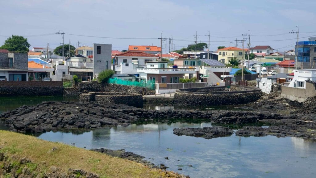 Tidal pools beside Jocheon show circular basalt weirs and stepped edges at low tide.