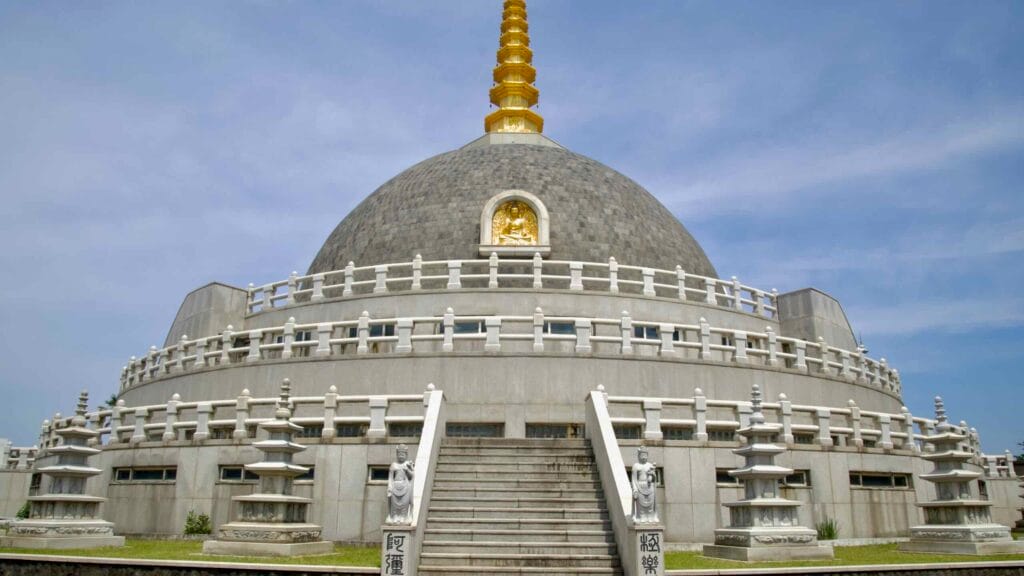 Buddha Sharira Stupa on front stairway shows tiered rails, guardian statues, and pagodas.