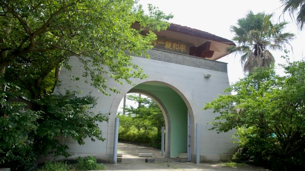 A twin-arch gate marks the entrance to the stupa grounds.