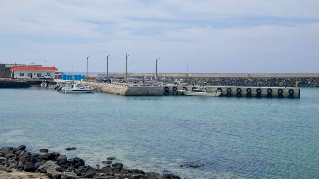 Small fishing boats tie to a concrete pier on the inner quay at Beollang Port.