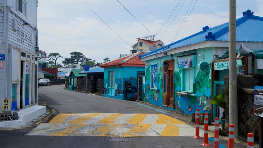 Colorful mural facades and low houses line a Samyang-dong street near the coast.