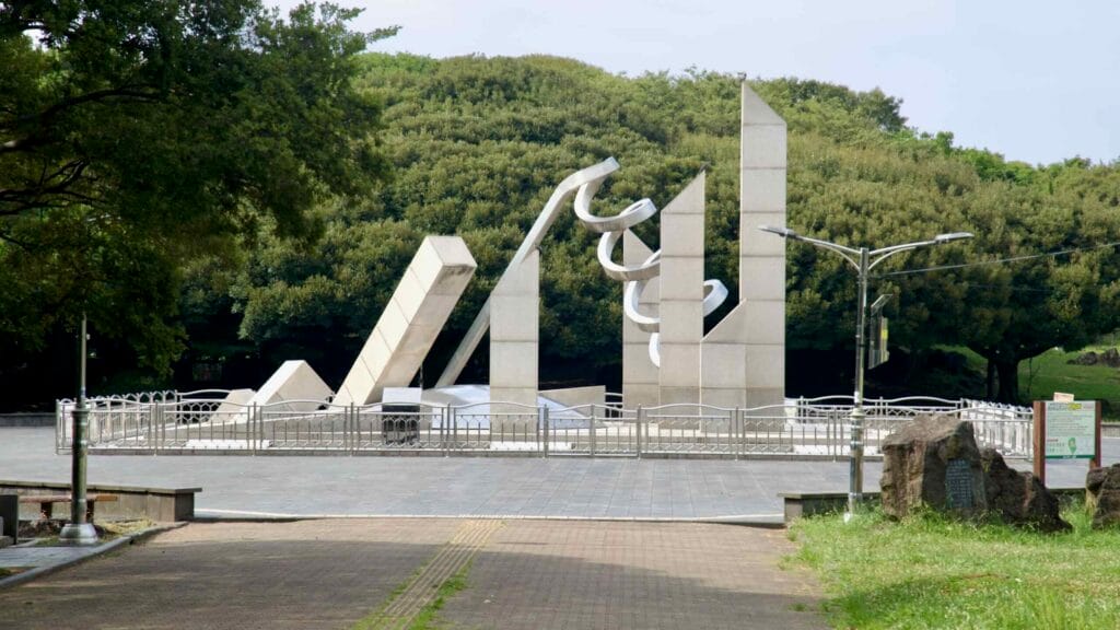 Granite pylons and metal forms compose the Olympic torch monument on Sinsan Park's central plaza.