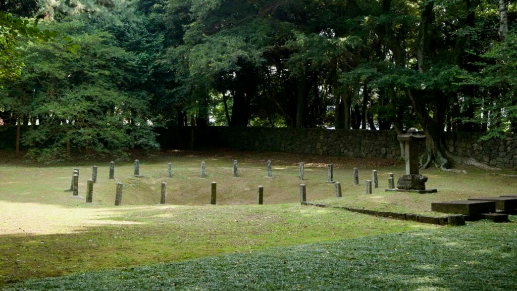 An oblique view shows the three-holes precinct with a basalt marker ring and stone stele.