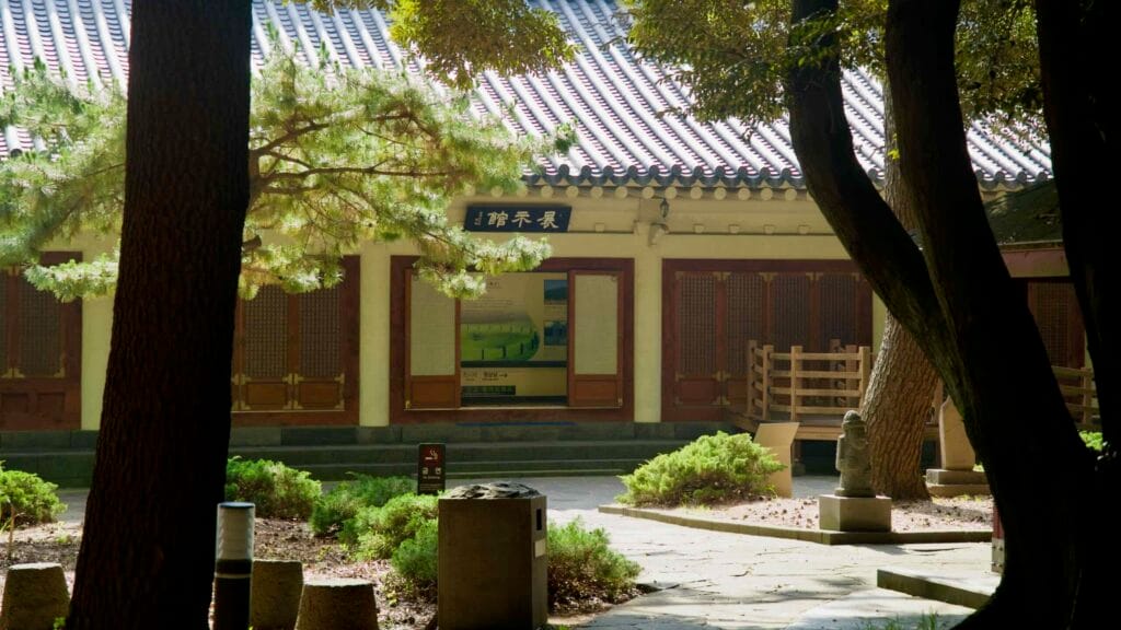 The Samseonghyeol museum shows display panels and wooden doors amid shrubs and stone paths.