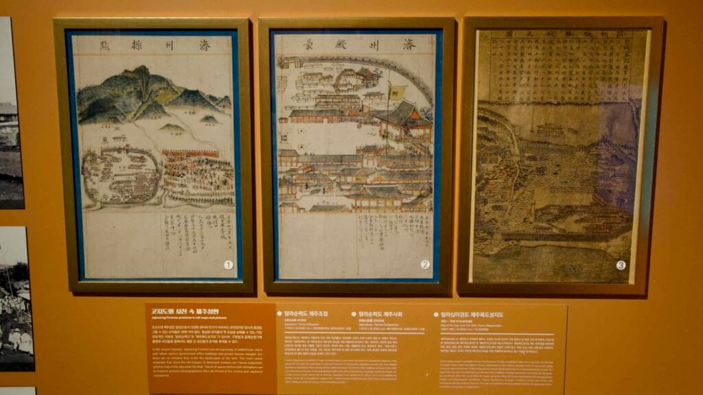 Three framed historic maps and Jeju scenes hang in a row with captions in the museum’s history gallery.