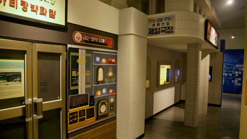 A corridor features recreated vintage storefronts, including a jewelry and watch shop.