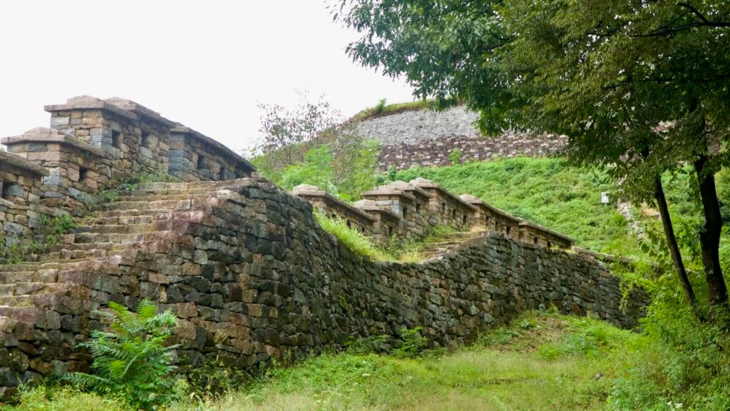 Stepped stone ramparts climb the hillside toward the main bastion of the fortress.