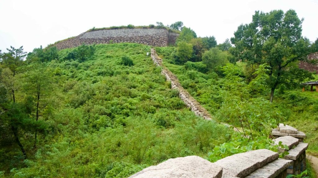 A narrow rough-stone stair climbs the fortress wall toward the main bastion.