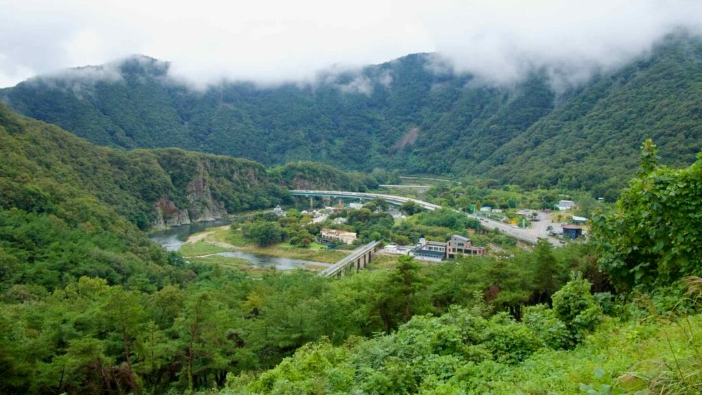 From the fortress, a high vantage shows the Yeong River bend and misty parallel roads.