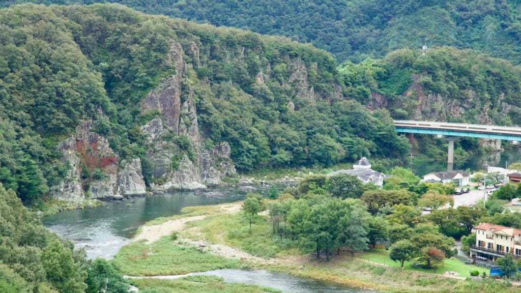 Across a green valley, mist clings to ridges while the Yeong River winds below the fortress.