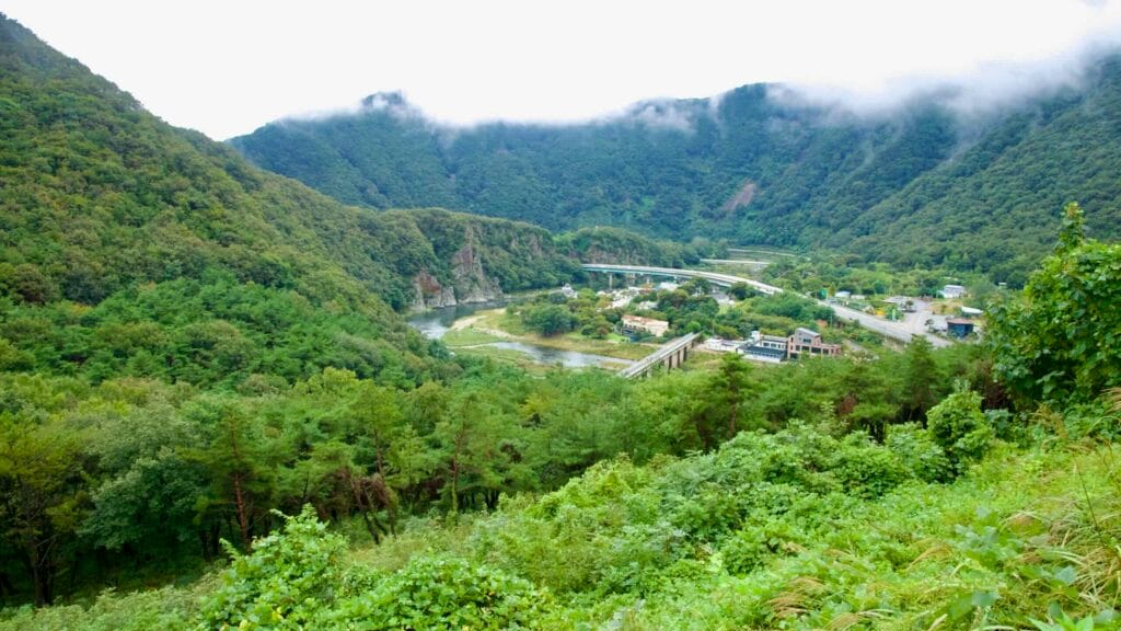 A closer look reveals cliffs, gravel bars, and green banks beneath Gomo Mountain Fortress.