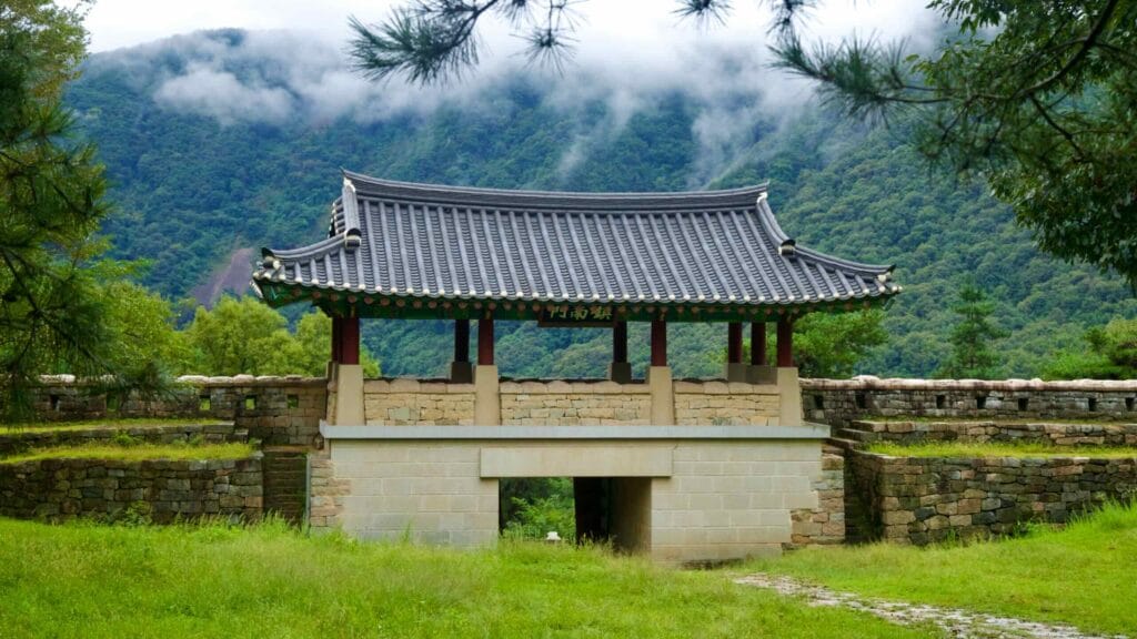 A tiled-roof gatehouse spans a stone arch at Gomo Mountain Fortress.