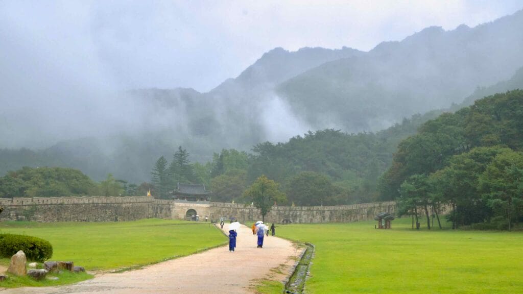 A misty walk leads toward Juheul Gate at Mungyeong Saejae Fortress after rain.