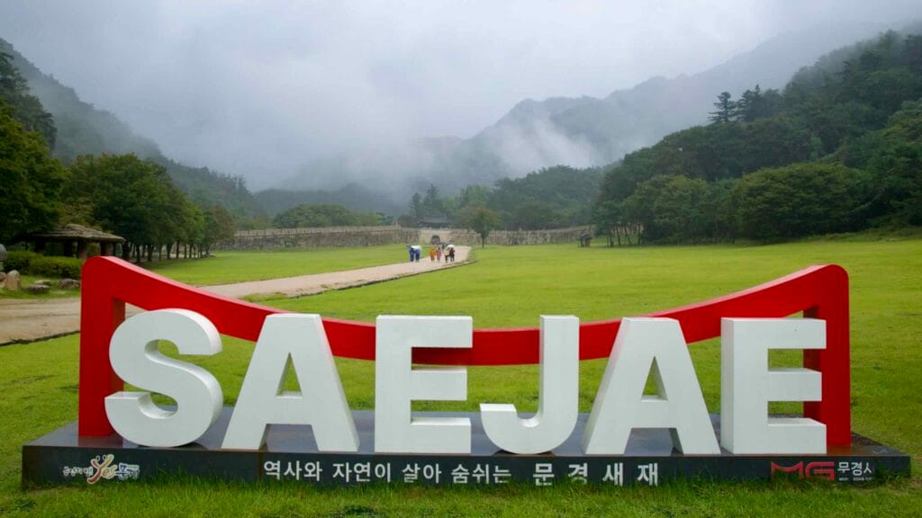 A large ‘SAEJAE’ sign overlooks the rainy parade ground at Mungyeong Saejae Fortress.
