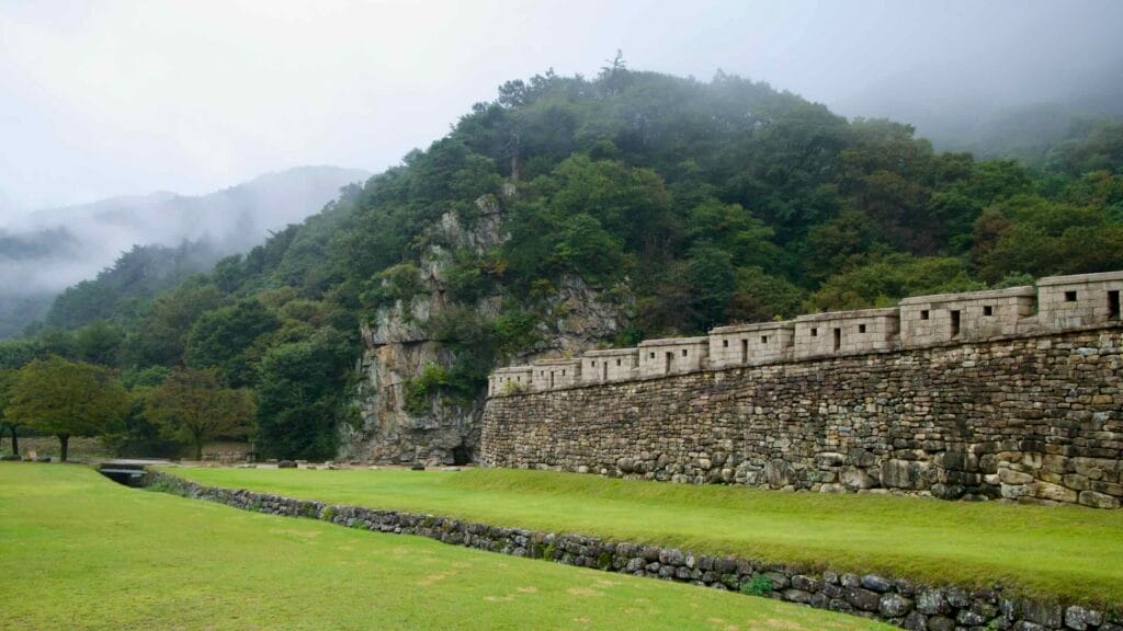 Fog curls over the ridge beside Mungyeong Saejae’s stone ramparts.